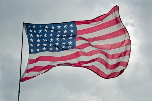 在多云的天空背景上的美国国旗 — 图库照片