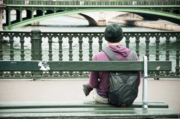 Mann sitzt auf Bank vor dem Fluss in Paris — Stockfoto