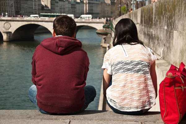 Par de turistas sentados en la frontera del río Sena en París —  Fotos de Stock