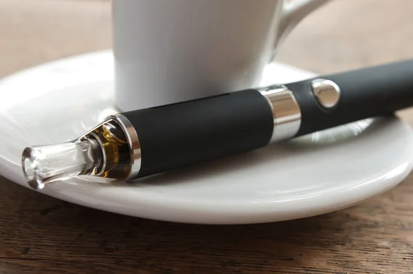 E-cigaretta és kávét a fából készült háttér — Stock Fotó