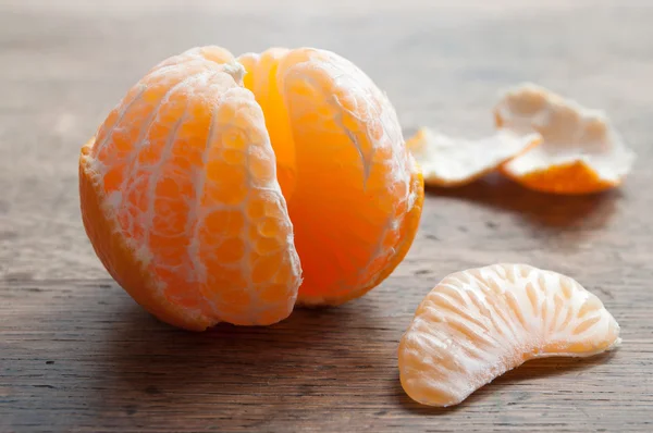 Gepelde mandarijn op houten achtergrond — Stockfoto