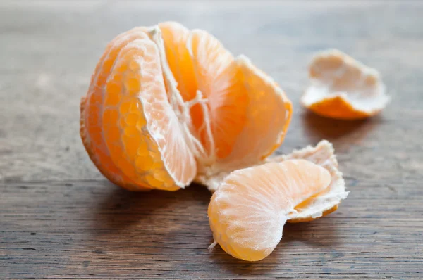 Mandarina pelada sobre fondo de madera — Foto de Stock