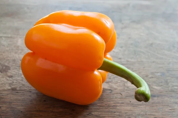 Oranje peper op houten achtergrond — Stockfoto