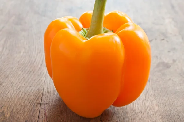 Oranje peper op houten achtergrond — Stockfoto