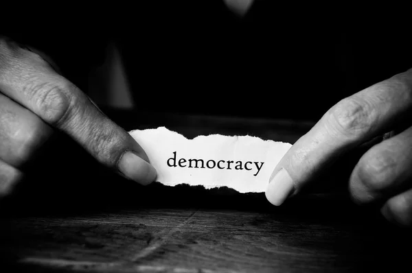 Concept woman with message on paper in hands - democracy — Stock Photo, Image