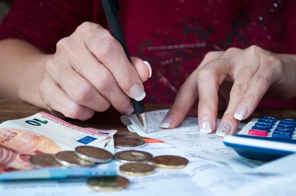 Närbild av kvinna med miniräknare och pengar på skrivbord — Stockfoto