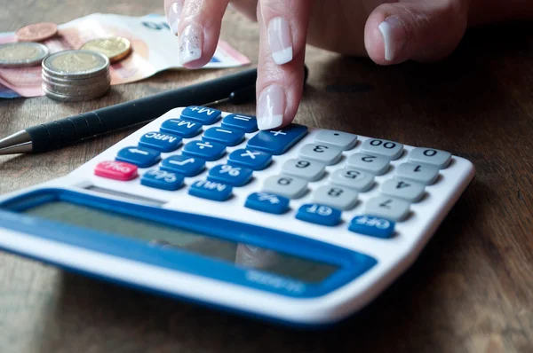 Penutupan wanita dengan kalkulator dan uang di atas meja — Stok Foto