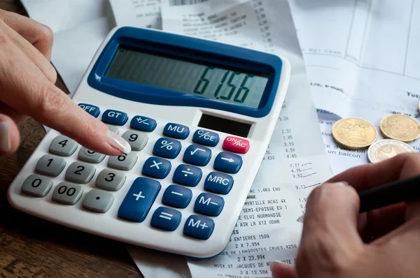 Close-up de mulher com calculadora e dinheiro na mesa — Fotografia de Stock