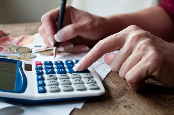 Close-up van vrouw met Rekenmachine en geld op Bureau Stockfoto