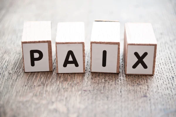 Kuben på trä skrivbord bakgrund - Paix (fred i franska) — Stockfoto