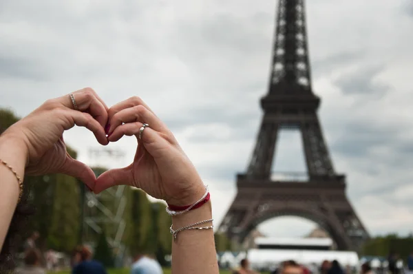 Close-up de mãos formando um coração na Torre Eiffel Paris — Fotografia de Stock