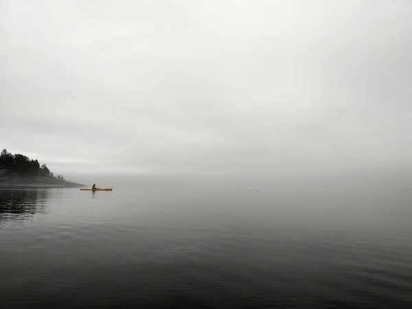 Un kayak solitario nada en la niebla en el lago Ladoga en Karelia.Wildlife.Russia. — Foto de Stock