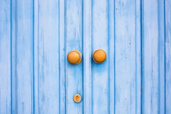 Żółty drzwi pokrętło na niebieskie drzwi drewniane. Śródziemnomorski styl. — Zdjęcie stockowe