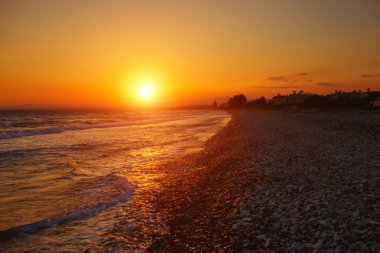 Pervolia village, Kıbrıs deniz üzerinde gün batımı. Çakıl plajı