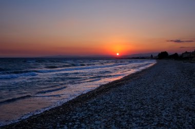 günbatımı üzerinde deniz ve dağlar.