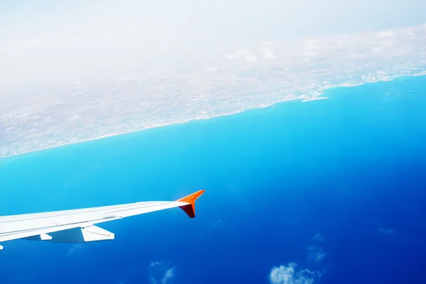 Wing of an airplane flying above the clouds — Stock Photo, Image