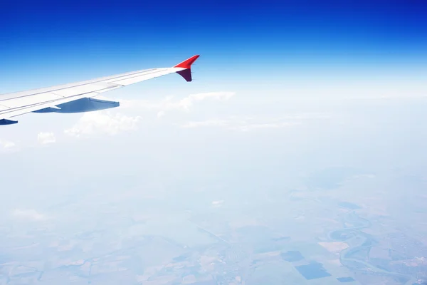 Wing of an airplane flying above the clouds — Stock Photo, Image