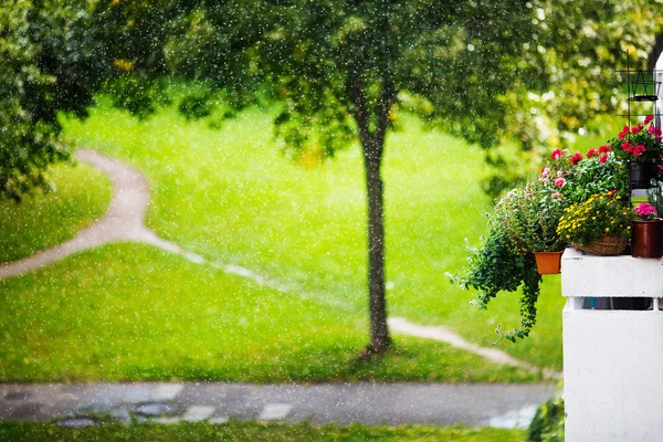 庭で太陽の光と雨を削除します。花とバルコニー. — ストック写真