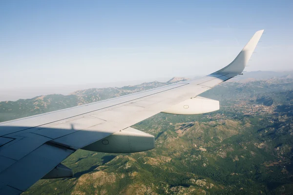 Vliegtuig vliegen boven de groene bergen — Stockfoto