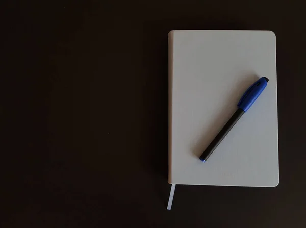 メモ帳とペンの黒の隔離された背景 — ストック写真