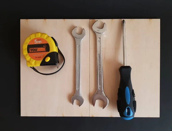 The tools for the job. Wrenches, screwdrivers, measuring tape on black isolated background