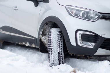 Grodno, Belarus-01.31.2021: A fragment of the front part of a Renault Capture or Renault Captur SUV with headlights, front bumper, fog lights on a winter road against the background of a field and forest