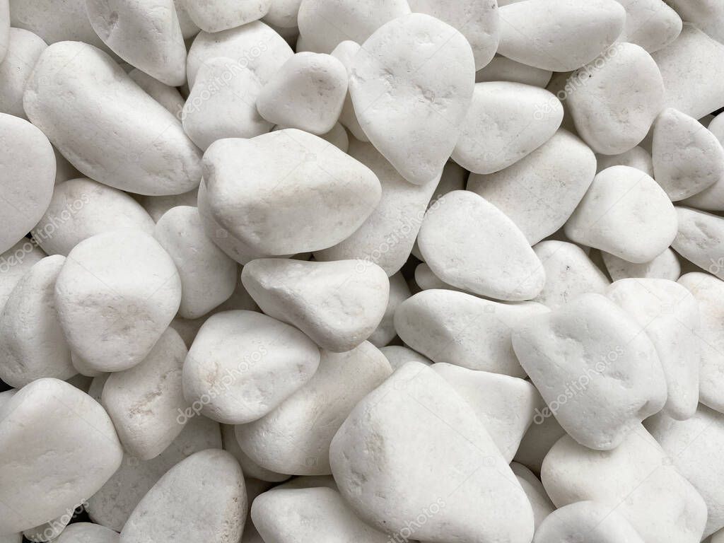 The background is made of white smooth pebbles of white color. Textured background of white pebbles
