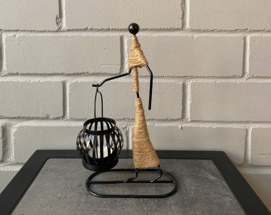 Dekoratif mum tutacağı ve yakın plan bir mum. Siyah mum tutacağı olan heykel.