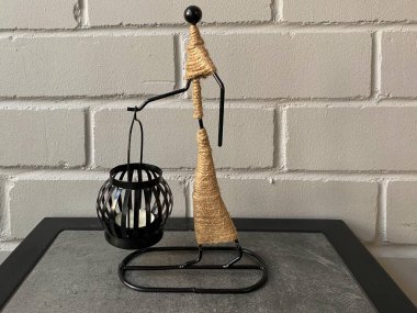 Dekoratif mum tutacağı ve yakın plan bir mum. Siyah mum tutacağı olan heykel.