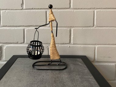 Dekoratif mum tutacağı ve yakın plan bir mum. Siyah mum tutacağı olan heykel.