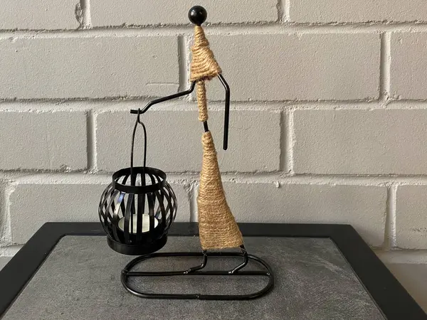 Dekoratif mum tutacağı ve yakın plan bir mum. Siyah mum tutacağı olan heykel.