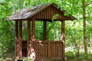 Ormanda dinlenmek için ahşap bir çardak duruyor.