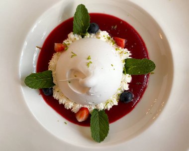 Beyaz tabakta leziz bir Pavlova tatlısı. Pavlova tatlı havadar yumuşak bir bulut ve harika bir karışım böğürtlen, krema ve protein hamuru.