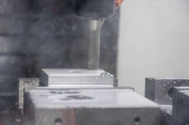 Metal çalışan CNC soğutuculu değirmen makinesi. Adam başı bir parça alüminyum. Cnc makinesinde endüstriyel metalcilik kesme işlemi.
