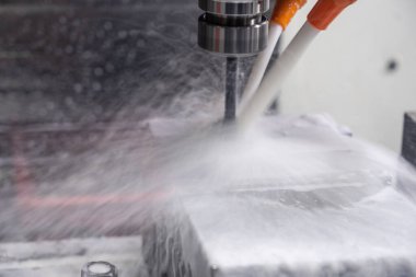 Metal çalışan CNC soğutuculu değirmen makinesi. Adam başı bir parça alüminyum. Cnc makinesinde endüstriyel metalcilik kesme işlemi.