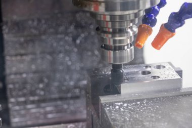 Metal çalışan CNC soğutuculu değirmen makinesi. Adam başı bir parça alüminyum. Cnc makinesinde endüstriyel metalcilik kesme işlemi.