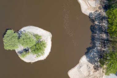 Sarı kazıcı kazıcı çalışıyor. Kazıcı kumu kazıyor, sudan toprak kazıyor. Endüstriyel hava aracı fotoğraf görüntüsü