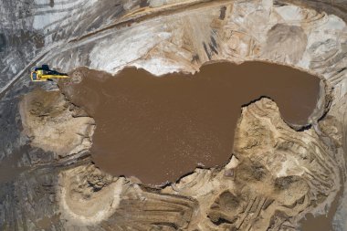 Sarı kazıcı kazıcı çalışıyor. Kazıcı kumu kazıyor, sudan toprak kazıyor. Endüstriyel hava aracı fotoğraf görüntüsü