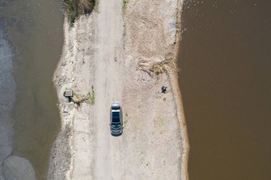 Sarı kazıcı kazıcı çalışıyor. Kazıcı kumu kazıyor, sudan toprak kazıyor. Endüstriyel hava aracı fotoğraf görüntüsü