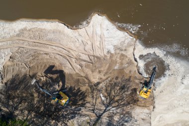 Sarı kazıcı kazıcı çalışıyor. Kazıcı kumu kazıyor, sudan toprak kazıyor. Endüstriyel hava aracı fotoğraf görüntüsü
