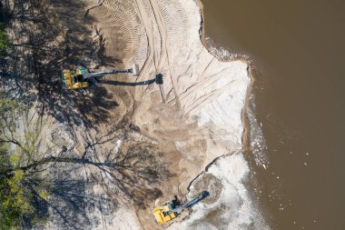 Sarı kazıcı kazıcı çalışıyor. Kazıcı kumu kazıyor, sudan toprak kazıyor. Endüstriyel hava aracı fotoğraf görüntüsü