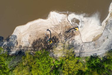 Sarı kazıcı kazıcı çalışıyor. Kazıcı kumu kazıyor, sudan toprak kazıyor. Endüstriyel hava aracı fotoğraf görüntüsü