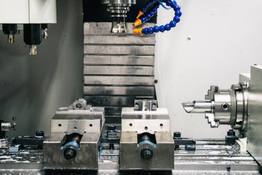 Metal çalışan CNC soğutuculu değirmen makinesi. Adam başı bir parça alüminyum. Cnc makinesinde endüstriyel metalcilik kesme işlemi.