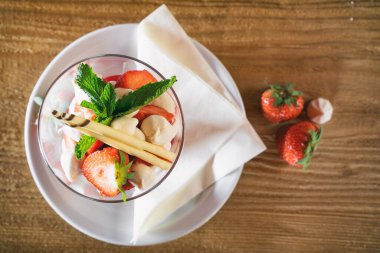 Meyvelerle süslenmiş kremalı çilekler. Elmalı tatlı, çilekli ve çeşitli meyveli.