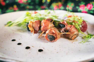 Kızarmış pastırmalı erik. Ahşap bir masada akşam yemeği aperatifi. Geleneksel Polonyalı Ünlü Mutfak