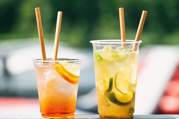 Cold ice beverage alcohol drink with fruits. Drikk with lemon,orange and ice. Water background.