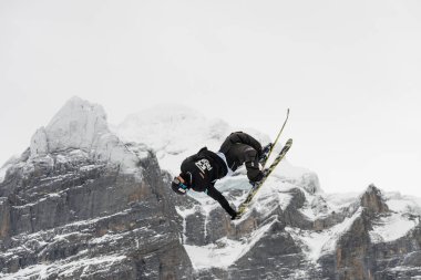 Arka plandaki Mittelhorn Dağı 'nda kar kayağı serbest stil büyük hava yarışması. Snowboard numaraları, kayak numaraları. Jungfrau bölgesi Grindelwald, İsviçre