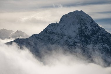 Kışın İsviçre dağlarının manzarası. Bulutlardaki Eiger, Monoch ve Jungfrau. İsviçre 'nin Jungfrauregion bölgesindeki İsviçre Alpleri