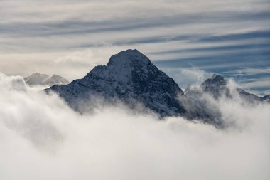 Kışın İsviçre dağlarının manzarası. Bulutlardaki Eiger, Monoch ve Jungfrau. İsviçre 'nin Jungfrauregion bölgesindeki İsviçre Alpleri