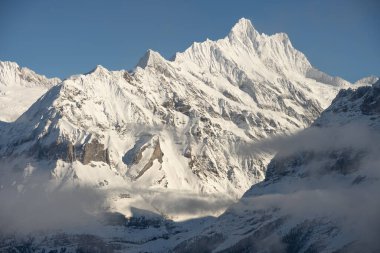 Kışın İsviçre dağlarının manzarası. Mittelhornin bulutları, Schreckhorn ve Wetterhorn. İsviçre 'nin Jungfrauregion bölgesindeki İsviçre Alpleri
